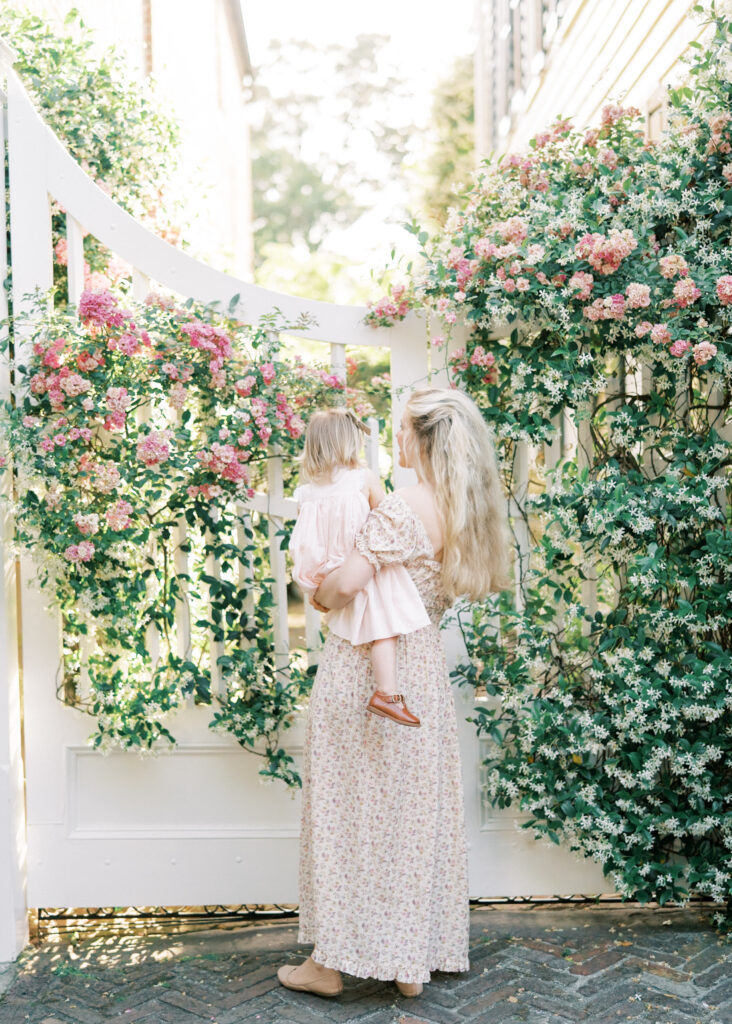 mom holding child with jasmine and roses in downtown charleston
