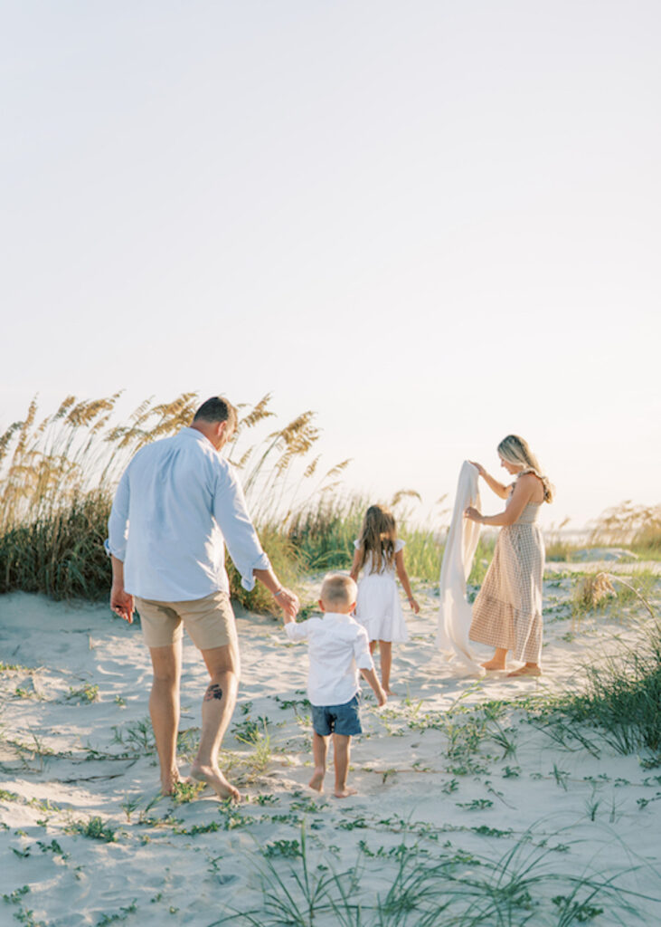 family walking on beach in neutral colors