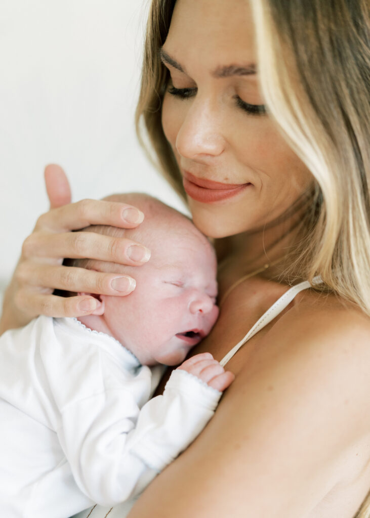 mom holding baby in nursery